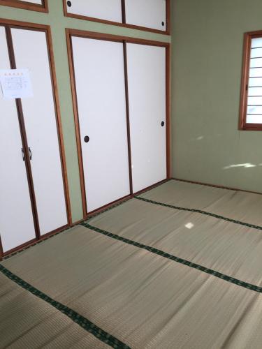 an empty room with a large room with windows at Iwamino Oyado lucere in Uradome