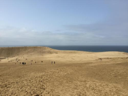 a group of people standing on a sand dune at Iwamino Oyado lucere in Uradome
