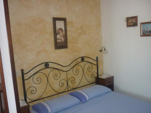 ein Schlafzimmer mit einem Bett mit blauer Bettwäsche und einem Bild an der Wand in der Unterkunft Albergo Vittoria in Taviano