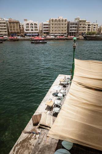 a dock with chairs and tables on the water at MAZMI CASA in Dubai