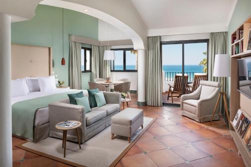 a bedroom with a bed and a living room at Palacio de Sancti Petri, a Gran Meliá - The Leading Hotels of the World in Chiclana de la Frontera