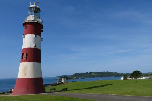 a red and white lighthouse sitting on top of a grass field at Ebrington Street View in Plymouth