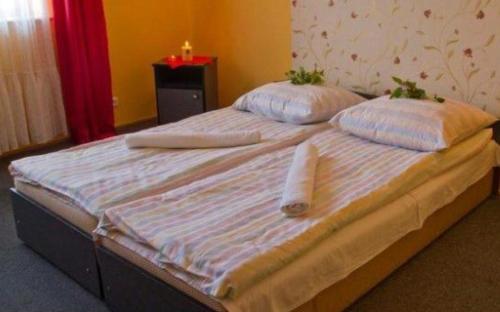 a large bed with two pillows on top of it at Hotel Restauracja U Guta in Klikuszowa