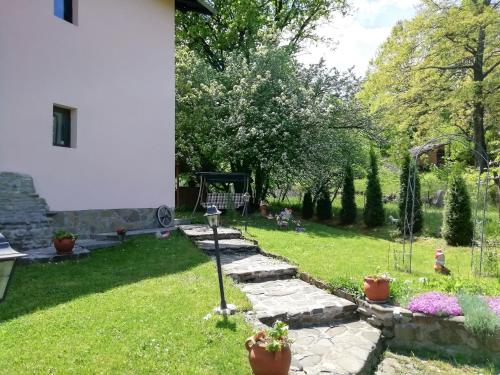 un jardin avec une passerelle en pierre et une aire de jeux dans l'établissement Guesthouse Vanessa, à Oreshak