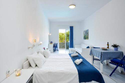 een witte slaapkamer met een groot bed en een tafel bij Marika Studios & Apartments in Georgioupolis
