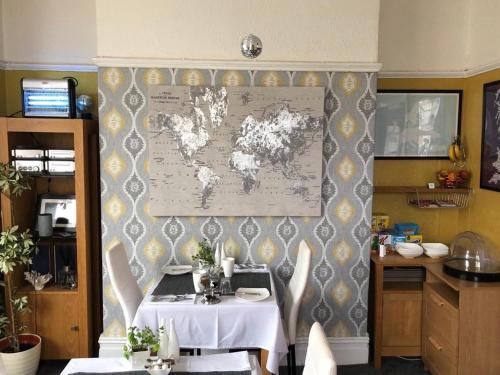 a dining room with a table and a map on the wall at Glen Guest House in Blackpool