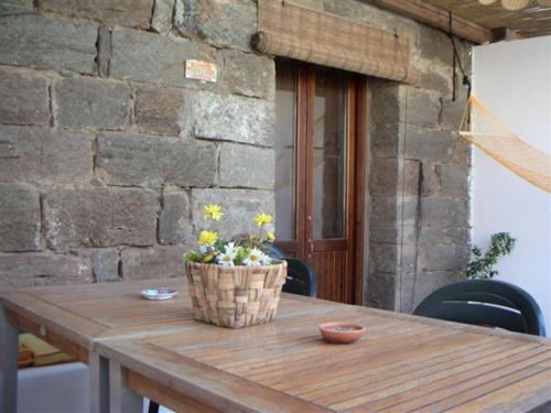 una mesa de madera con una cesta de flores. en Madilì, en Pantelleria