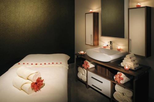 a bathroom with a sink and a bed with towels at Move On Beach Resort Al Khobar in Half Moon Bay