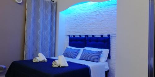 1 dormitorio azul y blanco con 1 cama y 2 toallas en SOGNO D'ESTATE 2, en Mazara del Vallo