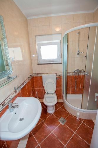 a bathroom with a toilet and a sink and a shower at APARTMAN KSENIJA KOVAČIĆ in Stanići