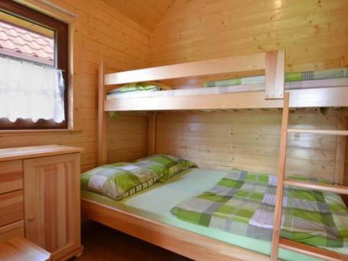 a bedroom with bunk beds in a wooden cabin at Domki Letniskowe WIKTORIA in Jezierzany