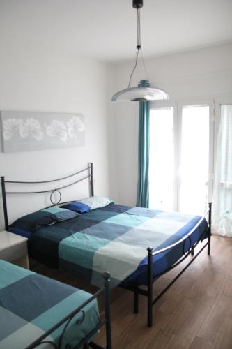 a bedroom with a bed with a blue comforter at Appartamenti La corte al Mare in Massa