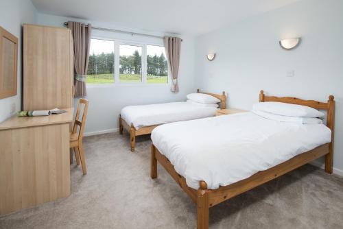 A bed or beds in a room at Brown Rigg Lodges