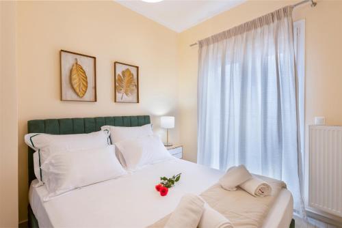a bedroom with a white bed and a window at Anaria Gold Suite in Ermoupoli