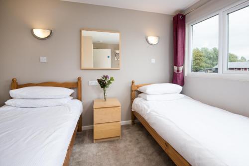 two beds in a room with a mirror and a window at Brown Rigg Lodges in Bellingham