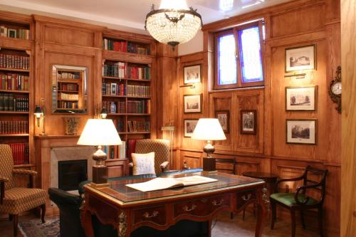 a library with a table and chairs and a fireplace at Hotel Gródek in Krakow