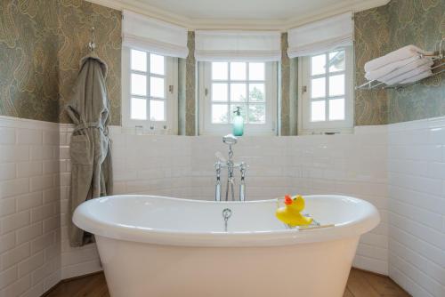 a bath tub with a rubber duck in a bathroom at Romantik B&B Zonnehuis in De Haan