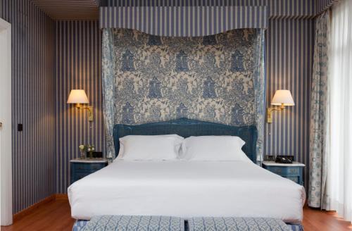 a bedroom with a large white bed and two lamps at Agumar in Madrid