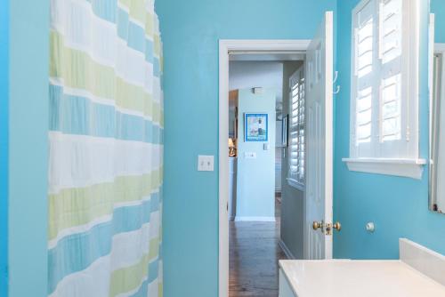 a bathroom with blue walls and a hallway at Somewhere in Time Too in Tybee Island