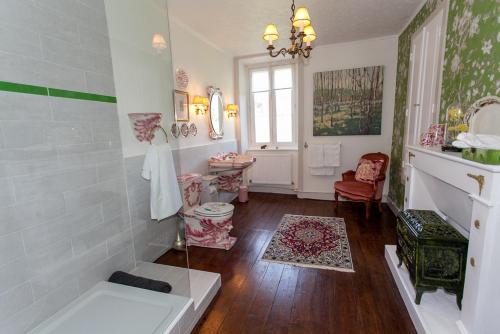 La salle de bains est pourvue d'une baignoire et d'un lavabo. dans l'établissement La Vieille Maison D'Aurin, à Bussière-Galant