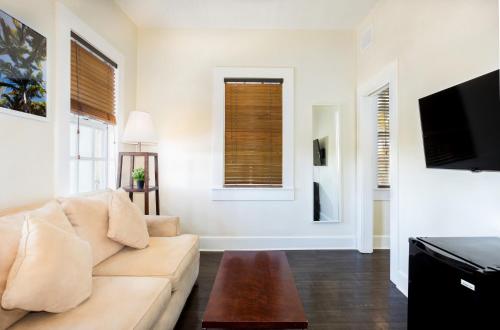 a living room with a couch and a tv at Southernmost Inn Adult Exclusive in Key West