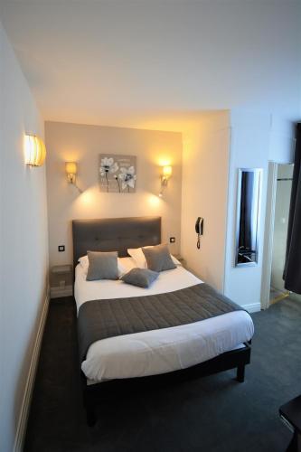 a bedroom with a large bed in a hotel room at Hotel Le Saint-Yves in Le Tréport