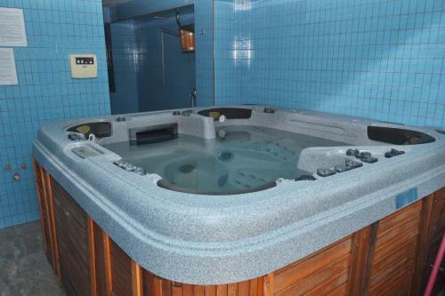 y baño de azulejos azules con bañera grande. en Къща за гости Суни Транс, en Smolyan