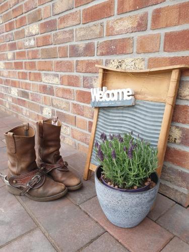 a pair of boots and a sign next to a brick wall at Ferienhausgebiet Oberlangen in Oberlangen