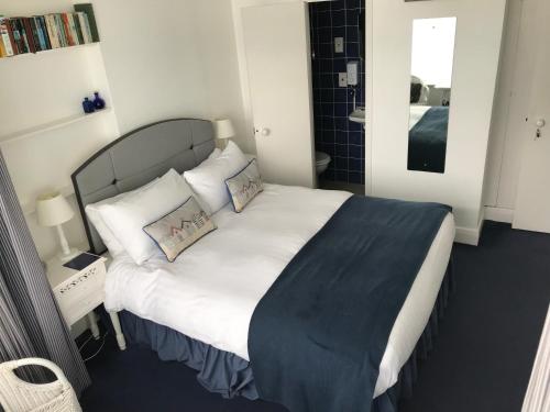 a bedroom with a large bed with white sheets and pillows at The Moorings B&B in Southend-on-Sea