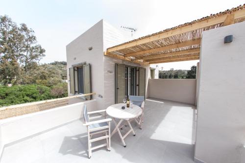 a white balcony with a white table and chairs at Vourkari Village in Vourkarion
