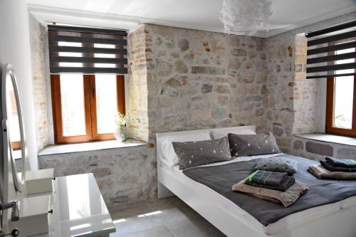 a bedroom with a white bed in a room with windows at Lana & Ena Apartments in Kotor