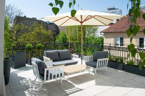 a patio with a table and chairs and an umbrella at eswiety10 in Poznań