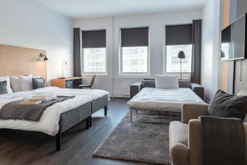 une chambre d'hôtel avec deux lits et un canapé dans l'établissement 201 Hotel, à Reykjavik