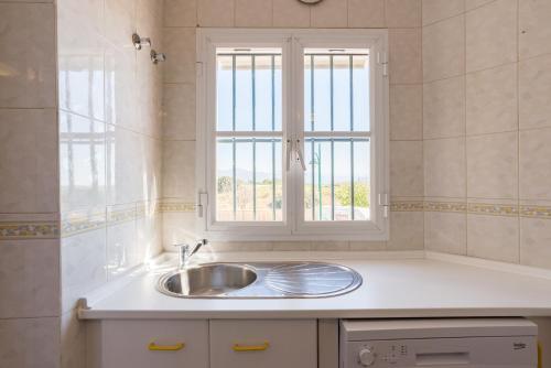 a kitchen with a sink and a window at Sandy Playa Golf Málaga con Parking in Málaga