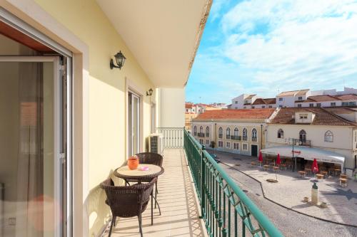 d'un balcon avec une table et des chaises offrant une vue sur la ville. dans l'établissement Apartamento Praia São Martinho do Porto, à São Martinho do Porto