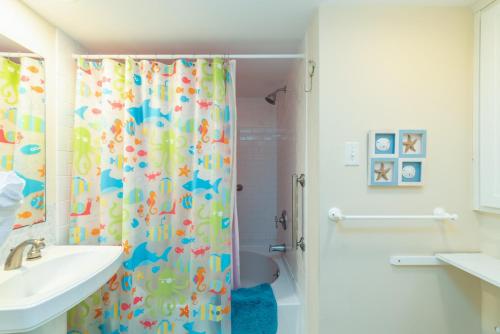 bagno con tenda per la doccia e lavandino di Sunny Side Up a Tybee Island