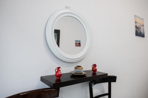 a mirror on a wall next to a black table at Akrogiali Apartments in Barbati