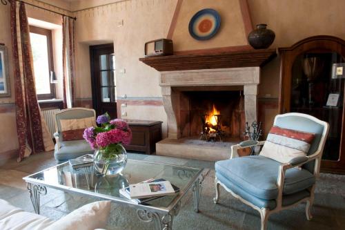ein Wohnzimmer mit Kamin, Tisch und Stühlen in der Unterkunft Tenuta La Cascinetta in Buriasco