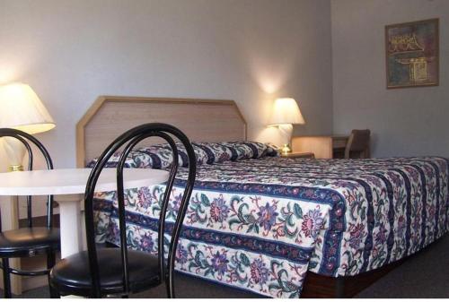 1 dormitorio con 1 cama con mesa y sillas en Celebration Inn, en Lewisburg