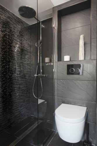 une salle de bain avec toilettes et douche en verre dans l'établissement Le Marais Calme et lumineux, à Paris