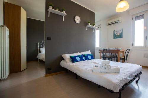 una camera da letto con un letto con cuscini blu e un tavolo di Apartment - Sacchini 16 a Milano