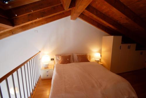 una camera con un letto bianco e 2 lampade di Appartamento Cristina - Rebomaholidays a Tignale