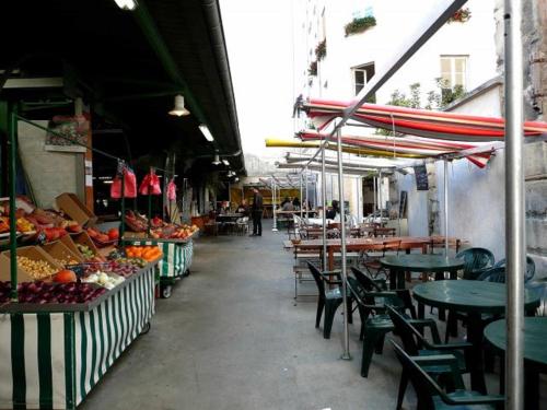 un marché en plein air avec des tables, des chaises et des fruits en exposition dans l'établissement Le Marais Calme et lumineux, à Paris