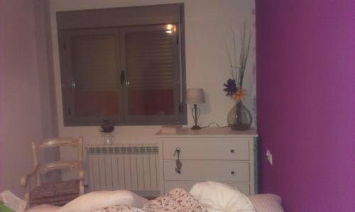 a bedroom with a window and a dresser and a bed at APARTAMENTO EN CAMPO DE GOLF in Cirueña