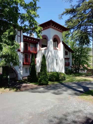 a large white building with trees in front of it at Appartement Le parc d Arradoy in Saint-Jean-Pied-de-Port