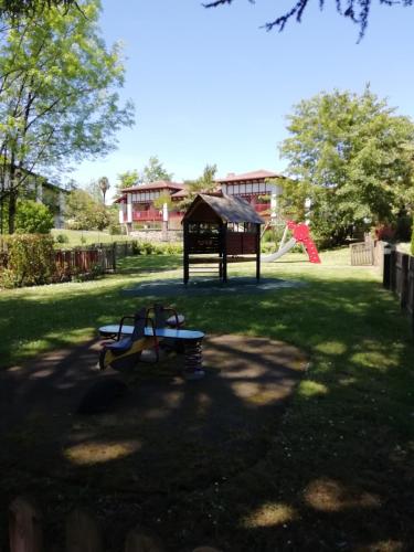 a park with a playground with a bench in the grass at Appartement Le parc d Arradoy in Saint-Jean-Pied-de-Port
