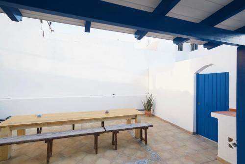 Cette chambre dispose d'une table et de bancs en bois. dans l'établissement Sol y Mar Surf Camp, à Corralejo