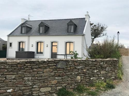 a white house behind a stone wall at Le Clos de la Pointe Saint-Mathieu in Plougonvelin
