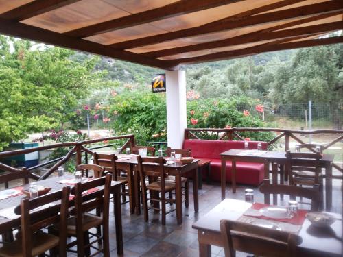 a restaurant with tables and chairs on a balcony at Menelaos Apartments in Lefokastro