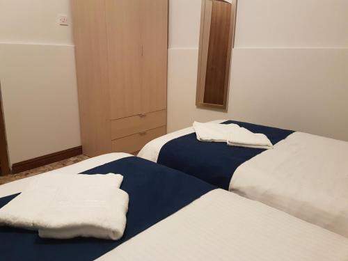 two beds in a room with towels on them at Le Malte House St. Julians in St Julian's